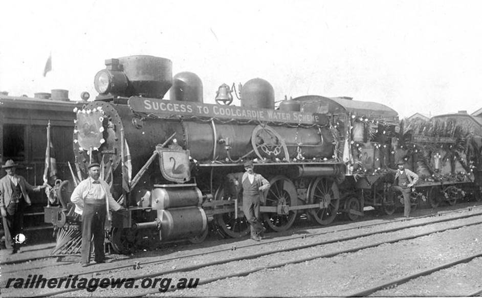 A group of men standing next to a train

Description automatically generated