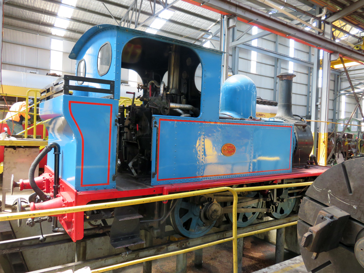 A blue train in a factory

Description automatically generated with low confidence